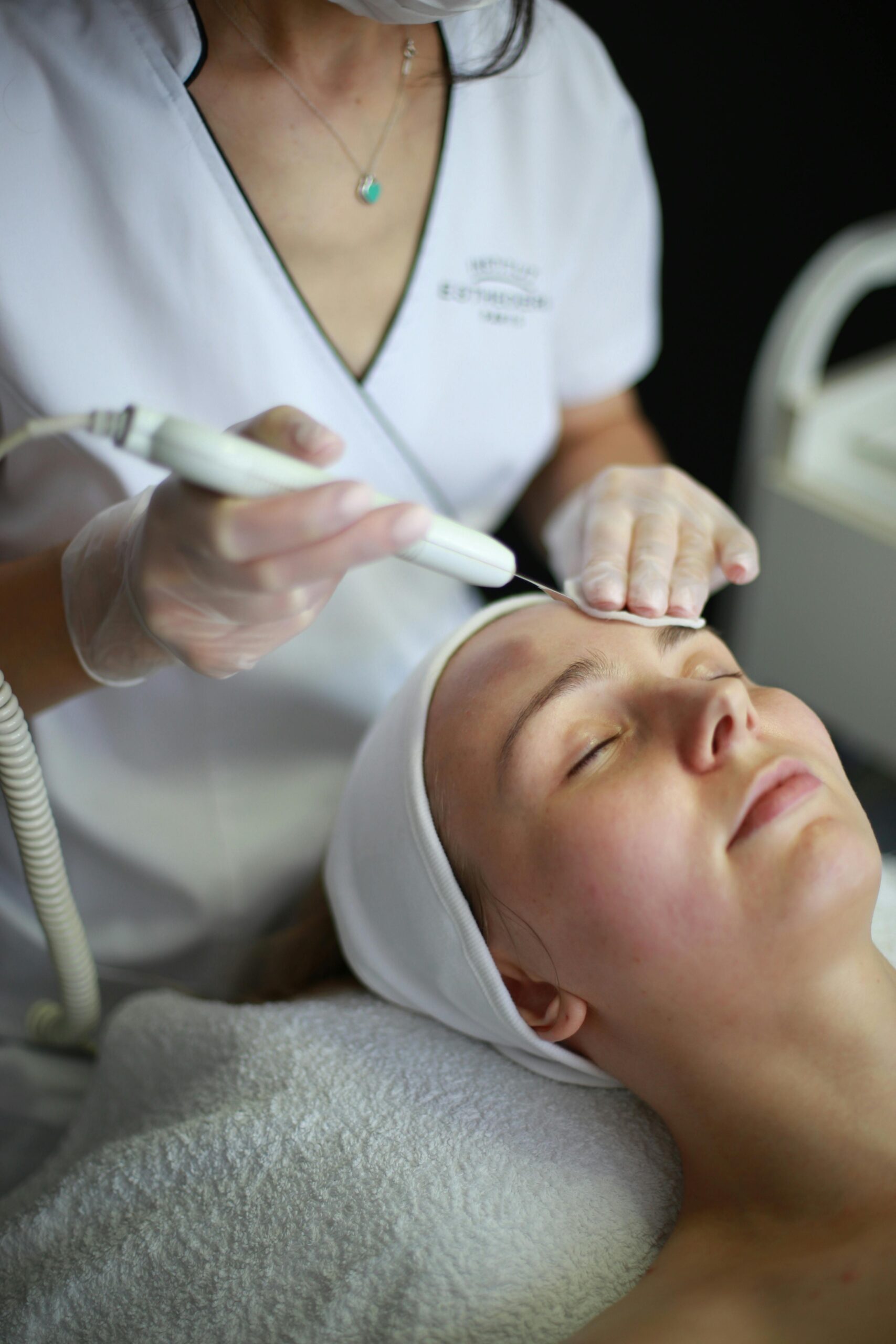 A woman receiving a calming facial treatment at a spa, highlighting relaxation and skincare.
